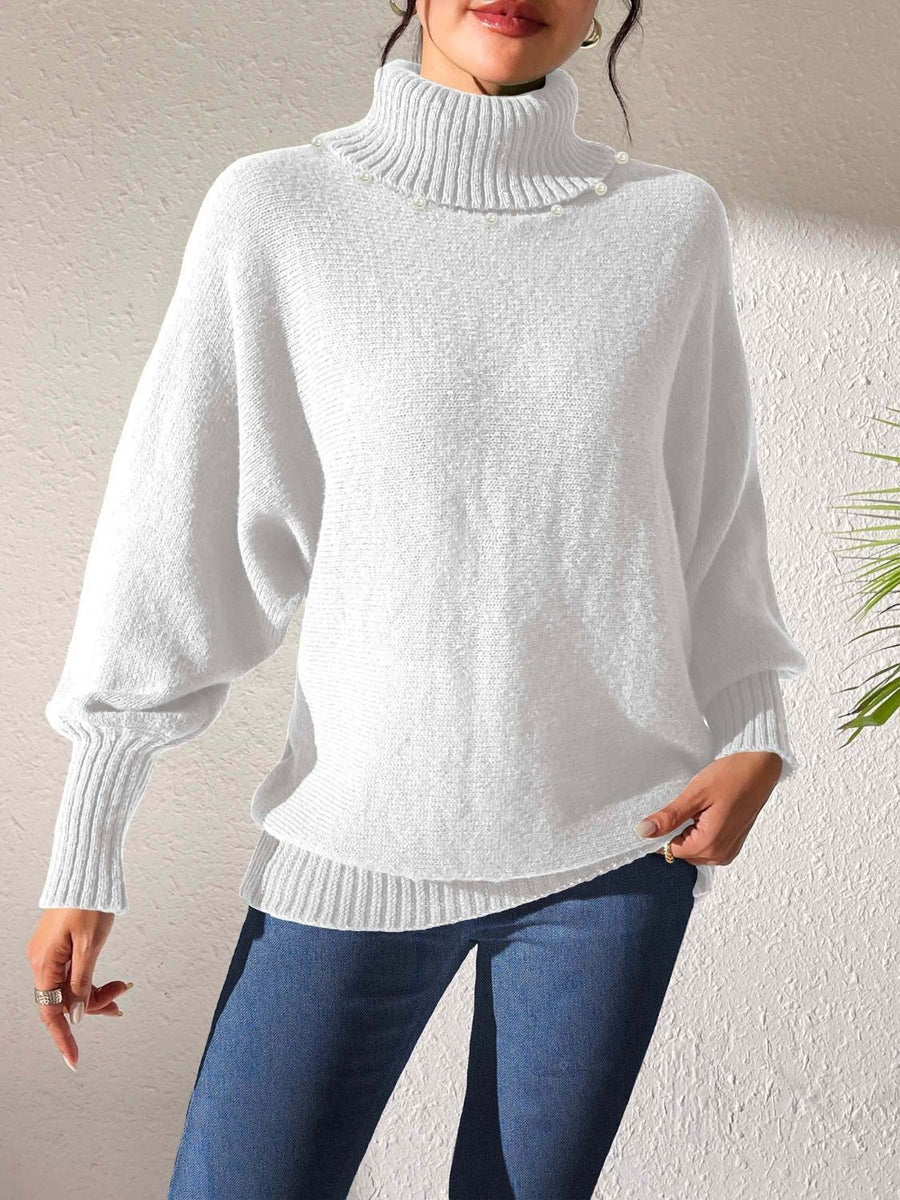 White knit turtleneck sweater with dolman sleeves and pearl embellishments.