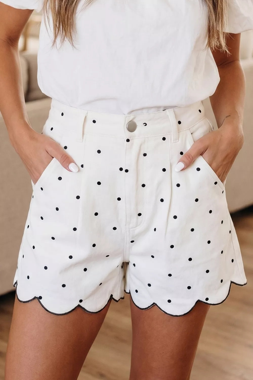 White polka dot chino shorts with scalloped hem and black trim.