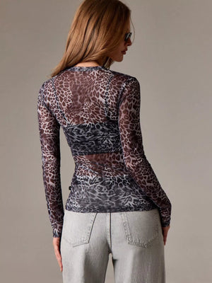 Sheer long-sleeve animal print top in leopard pattern, styled with a bra and light wash jeans.