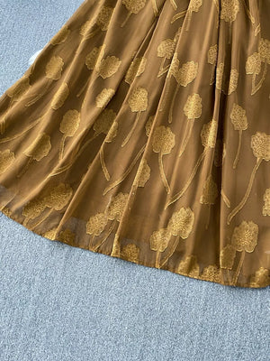 Brown chiffon maxi dress with gold floral embroidery and a belted waist.