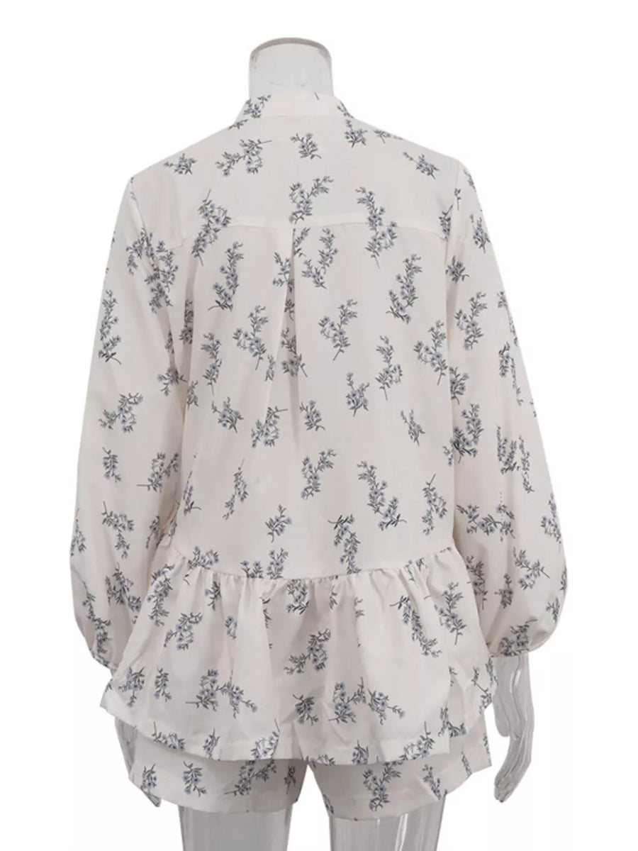 White floral print pajama set with ruffled hem shorts and long sleeve top.