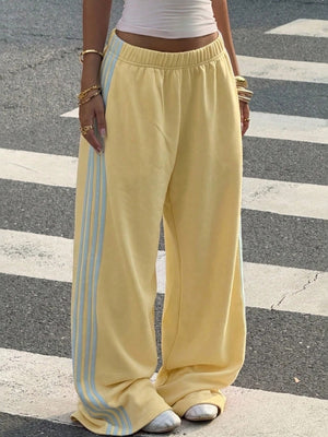 track pants in yellow featuring high-waisted and wide-leg fit