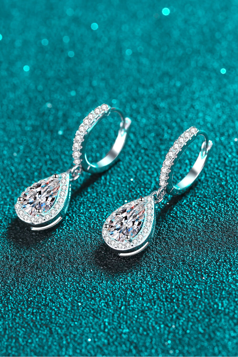 Silver teardrop halo hoop earrings with pavé accents and a large faceted stone.