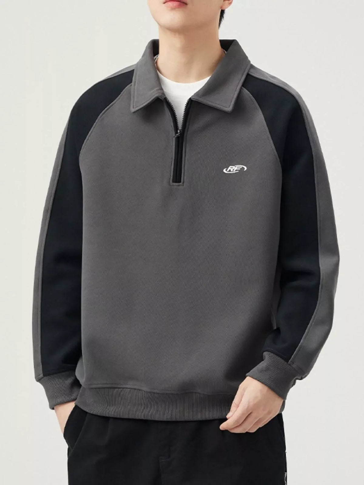 Men's dark gray raglan quarter zip sweatshirt with black sleeves and contrast stitching.