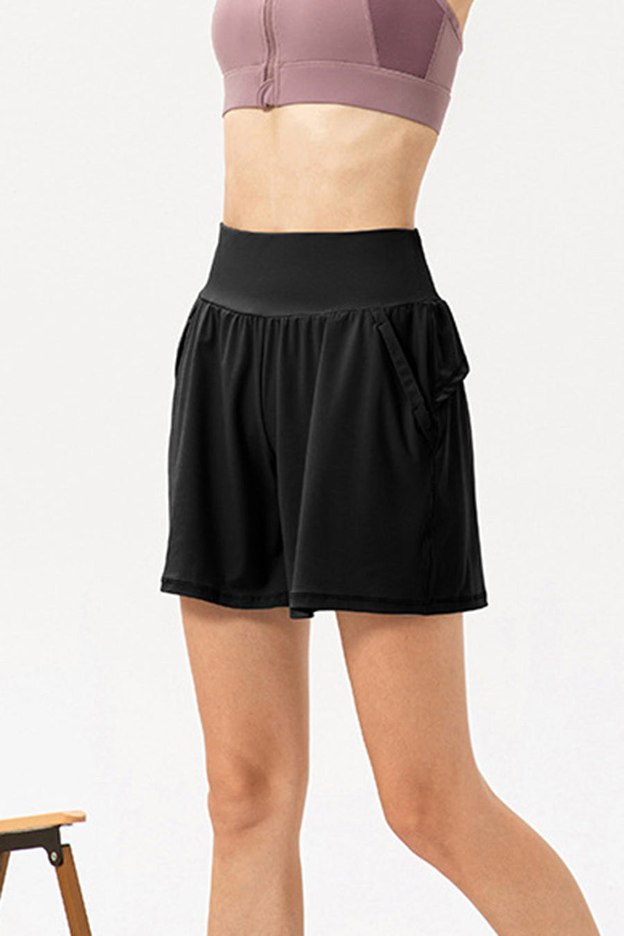 Black active shorts with layered pockets and a high-rise elastic waistband.