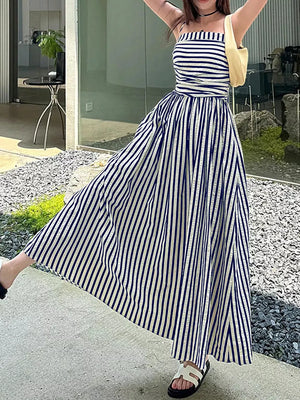 Navy and white striped maxi dress with spaghetti straps, cinched waist, and a thigh-high slit.