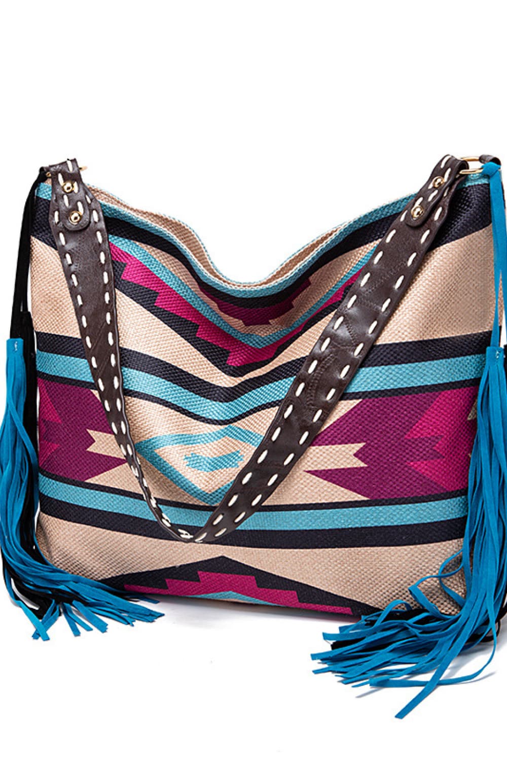 Southwestern fringe hobo bag in multicolor canvas with brown leather strap and blue fringe detail.