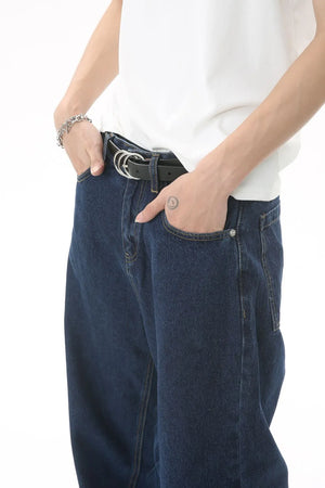 Baggy dark wash denim jeans with a subtle flare, styled with a white t-shirt and black belt.