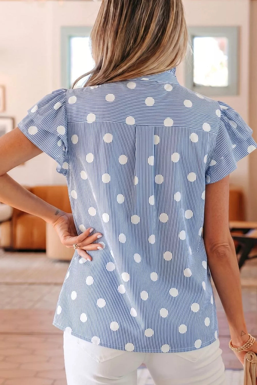 Blue and white polka dot and stripe ruffled shirt with button details.