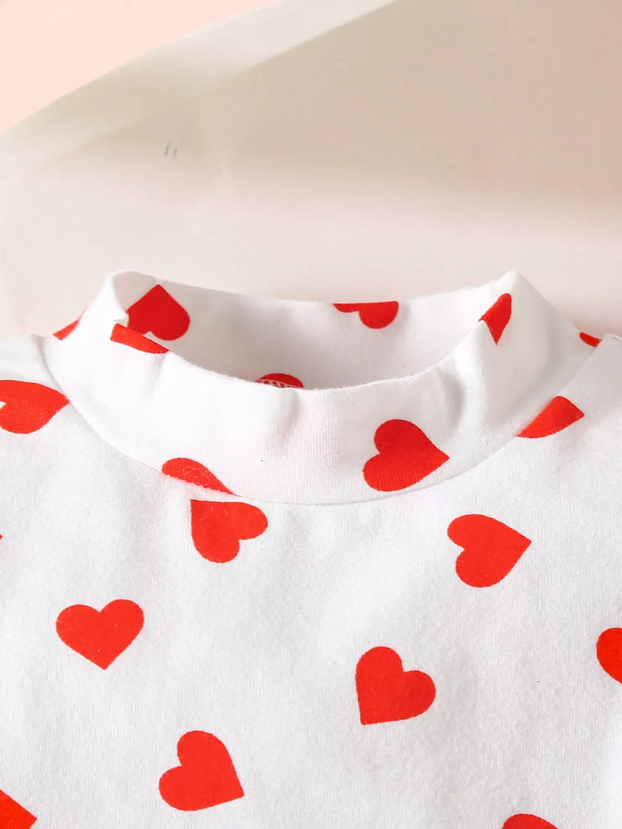 White long sleeve top with red heart print and mock neck