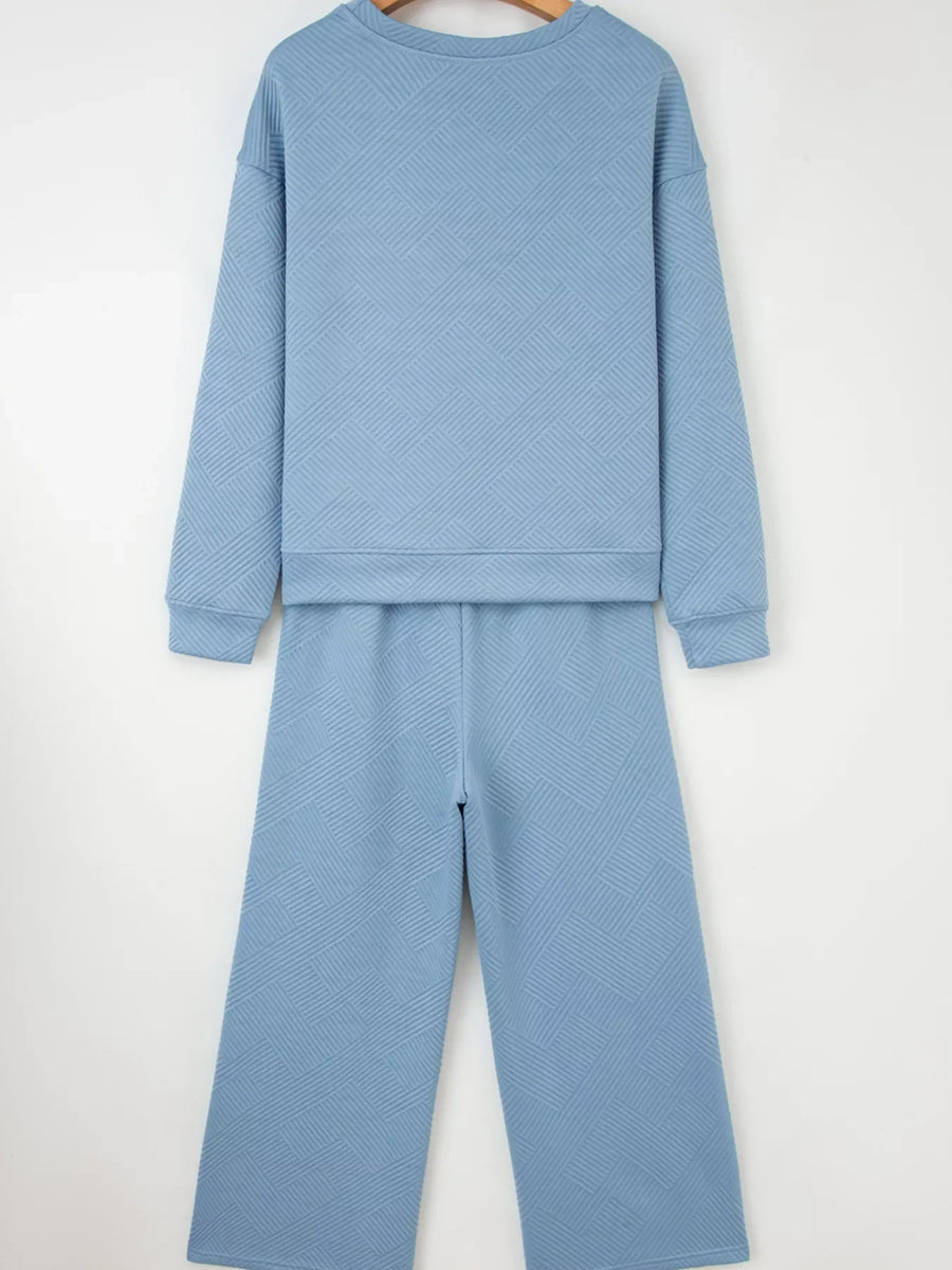 Light blue textured drawstring two-piece set with crew neck sweatshirt and wide leg pants.