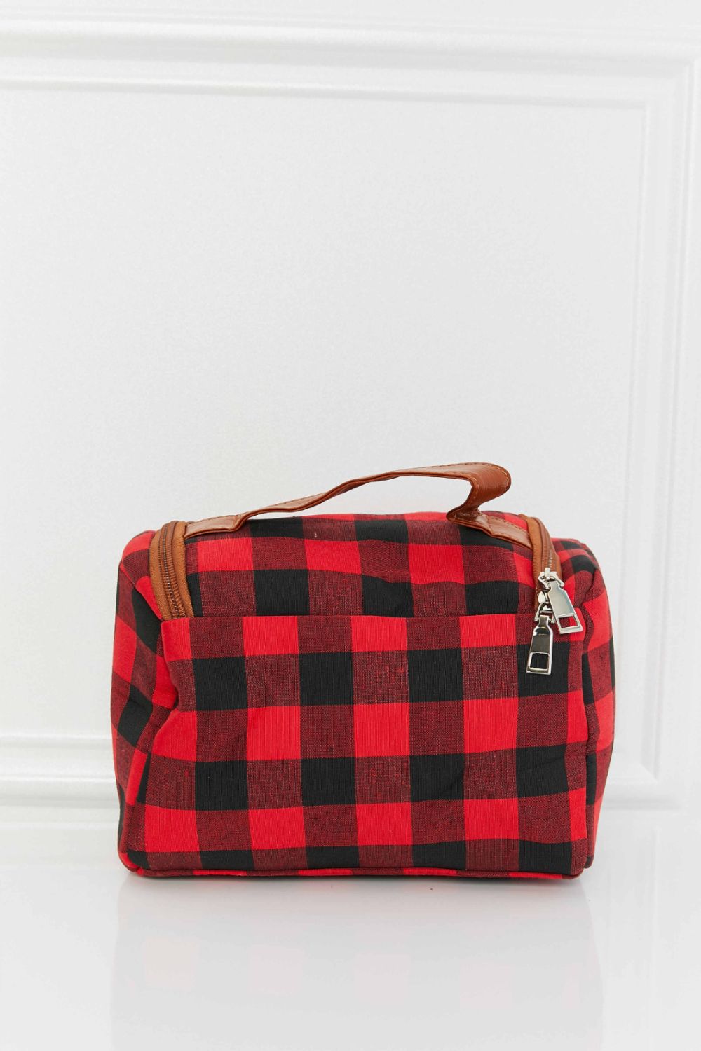 Red and black buffalo check travel case with faux leather handle and zipper detail.