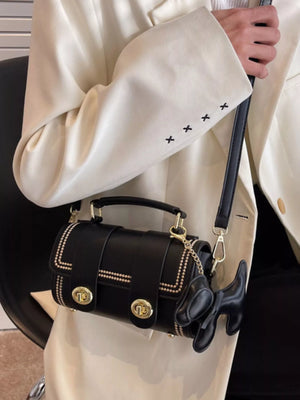 Black PU leather crossbody bag with gold hardware and dog charm accessory