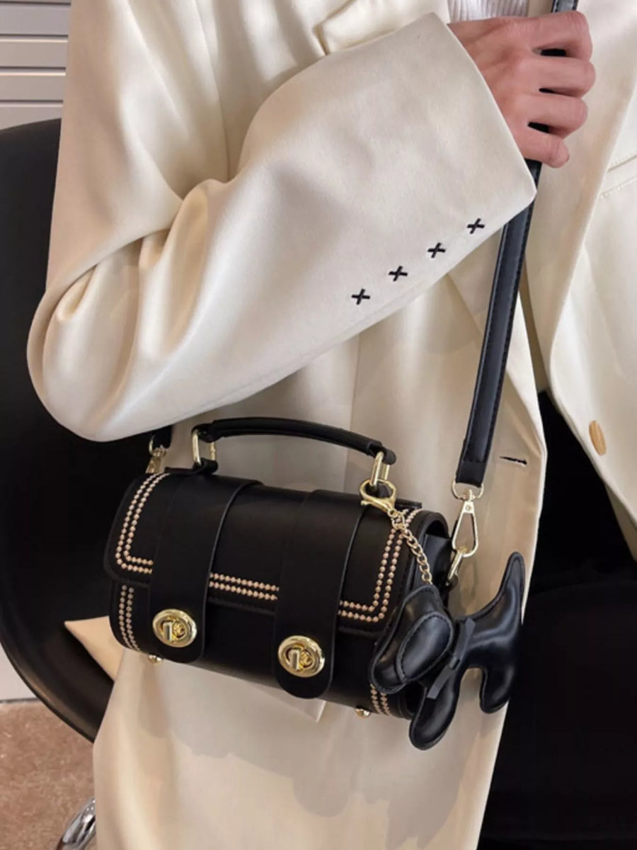 Black PU leather crossbody bag with gold hardware and dog charm accessory