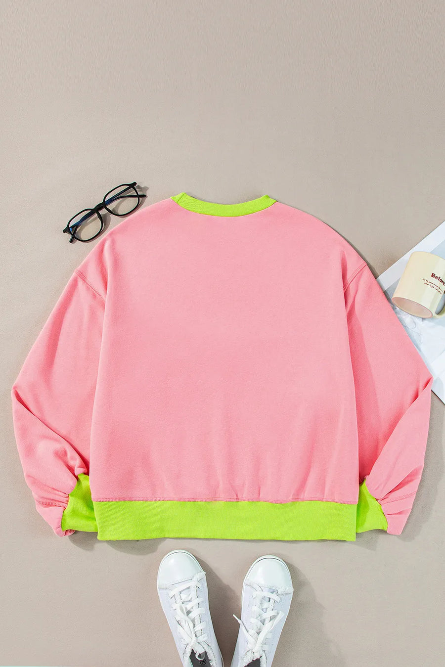 Blush pink sweatshirt with neon green trim and cuffs.