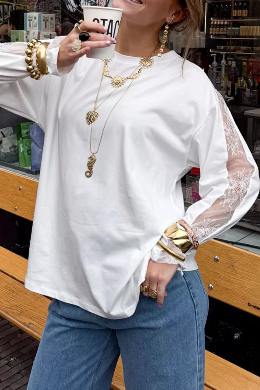 White long sleeve shirt with crew neck and lace-embellished sleeves.