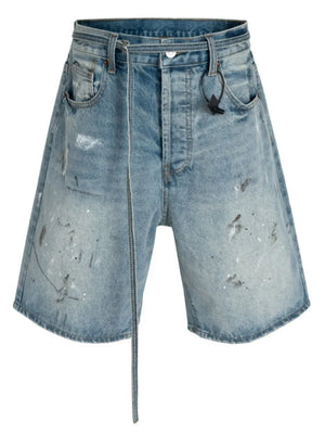 Distressed denim bermuda shorts in medium wash with paint splatters and a tie waist.