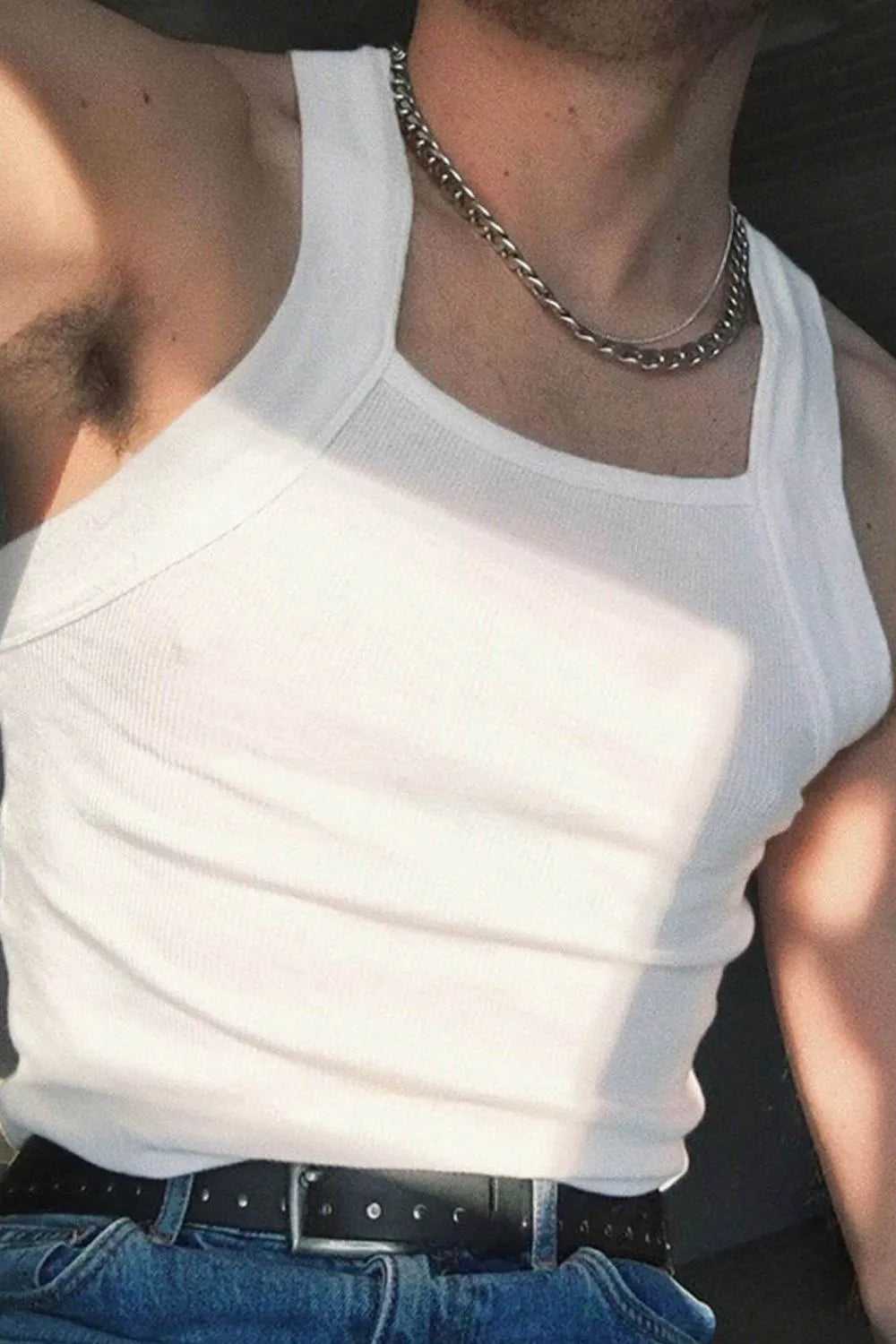 White ribbed tank top with square neckline, styled with jeans and a belt.