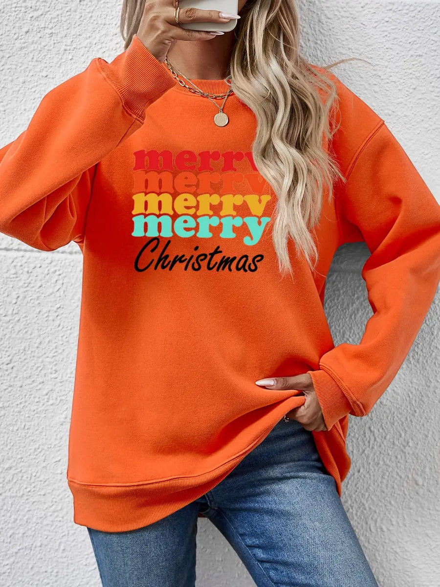 Orange graphic sweatshirt with retro "Merry Christmas" text in stacked, colorful lettering.