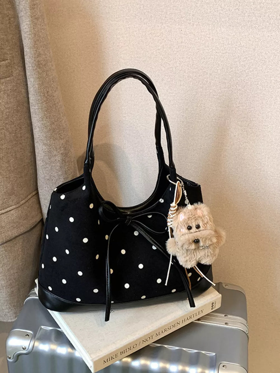 Black polka dot shoulder bag with bow detail and fuzzy charm