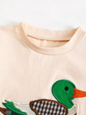 Baby set with playful duck appliqué on peach fabric.