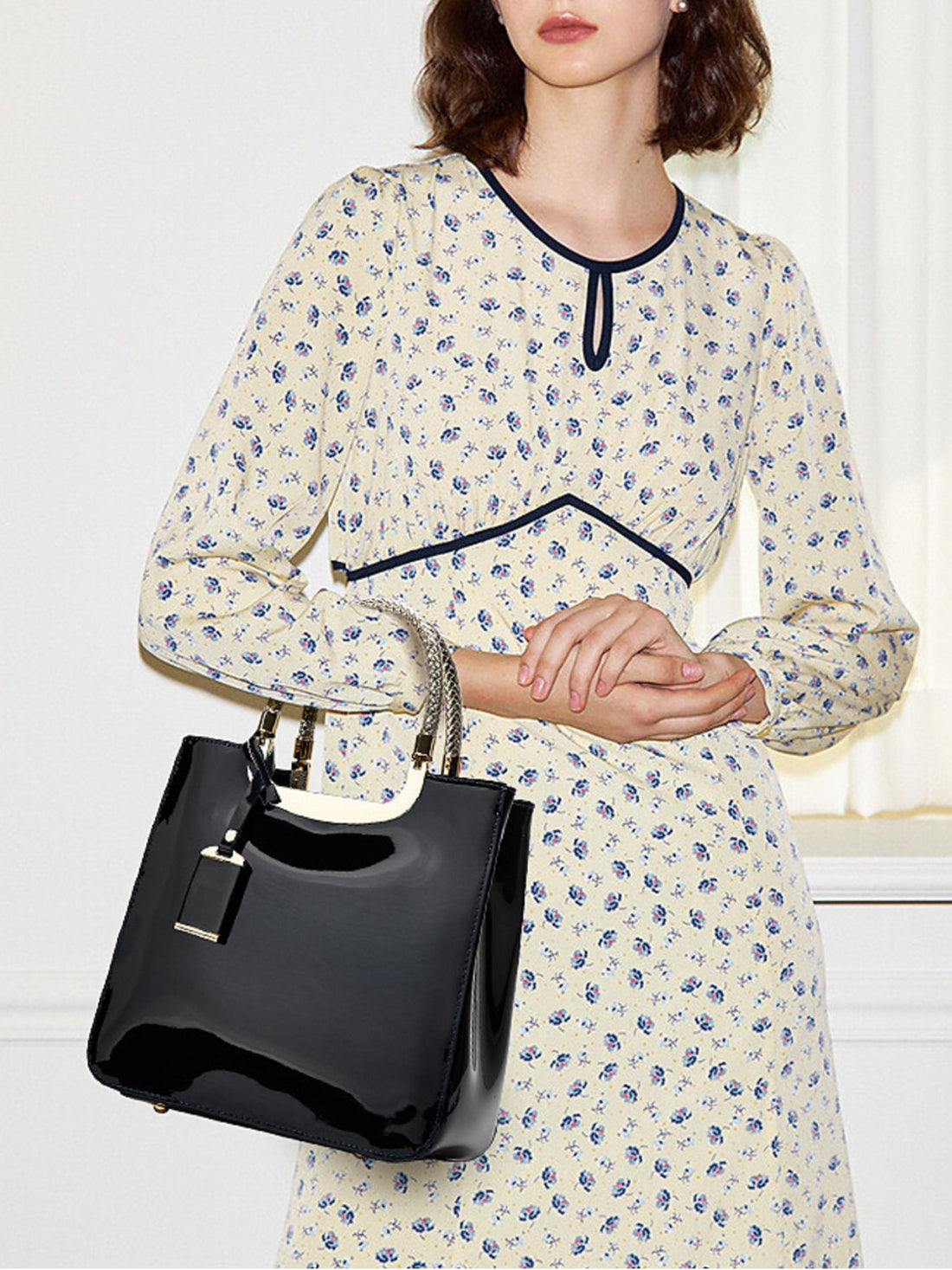 handbag in black featuring metallic handle and boxy fit