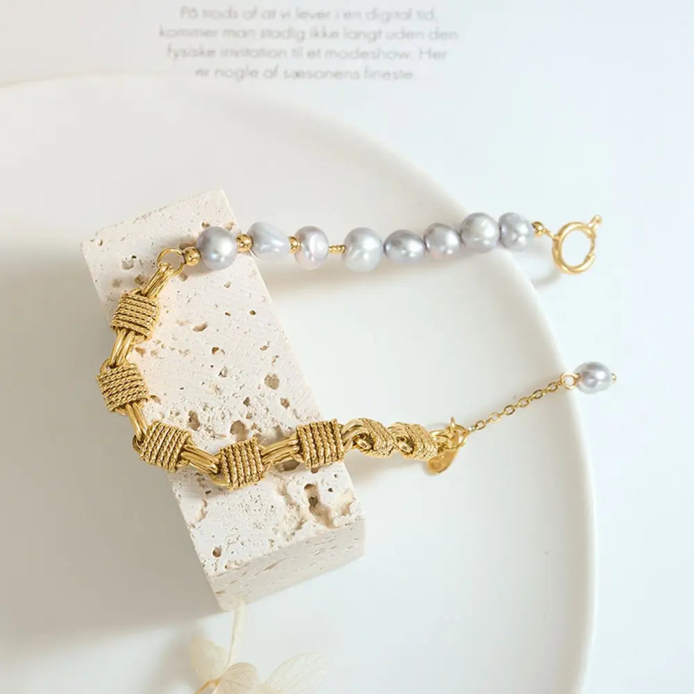Gold bracelet with asymmetrical pearl and knotwork details