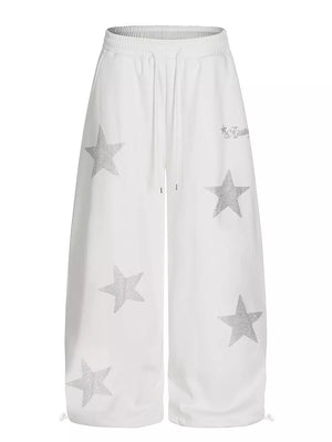 White wide leg sweatpants with all-over silver star embellishments and drawstring waist.