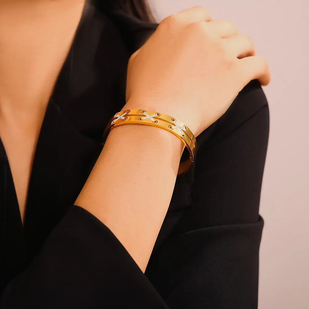 Gold cuff bracelet with diamond laced detail and subtle crisscross pattern.