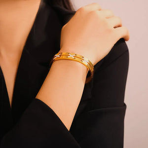 Gold cuff bracelet with diamond laced detail and subtle crisscross pattern.