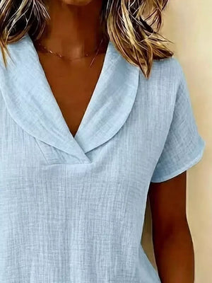 Light blue textured blouse with a V-neck and short sleeves.