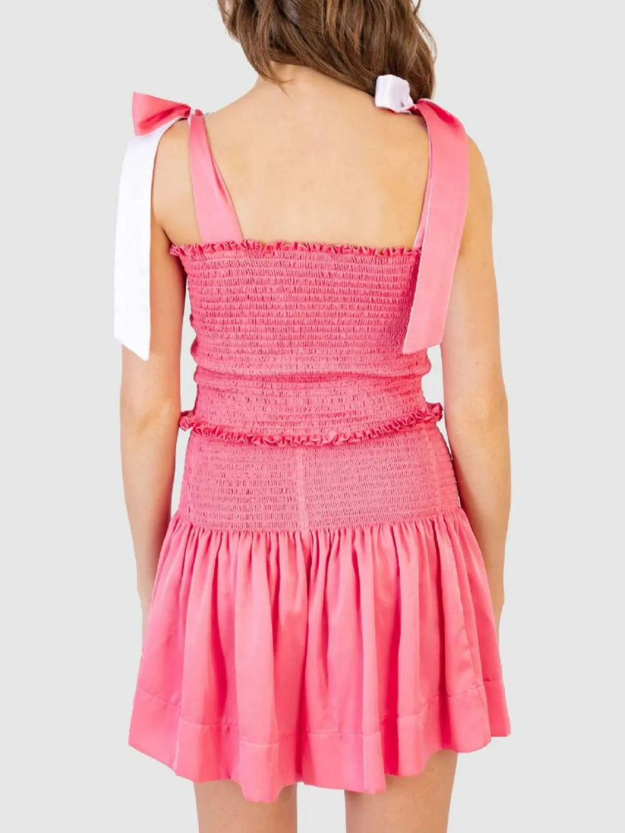 Smocked bodice and skirt set in strawberry pink with tie shoulder straps and ruffled trim.
