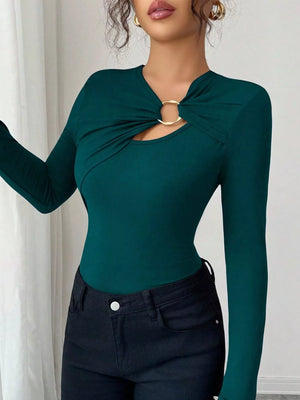 Teal long-sleeve tee with asymmetrical cutout and gold ring detail.