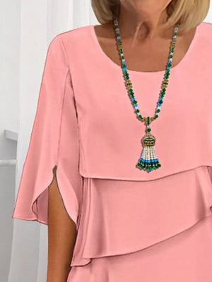 Coral ruffled layered flutter sleeve dress with tiered detail and statement necklace.