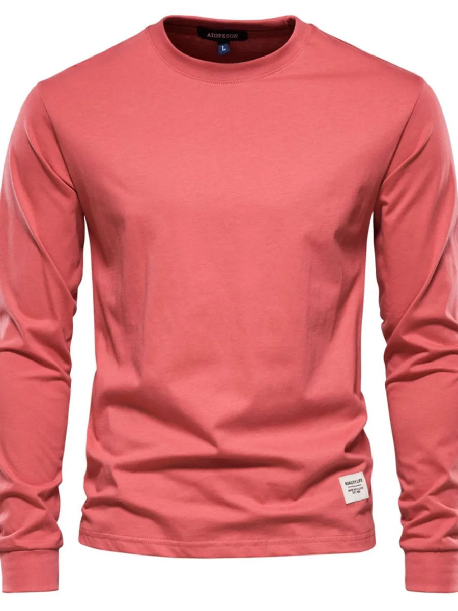 Essential crewneck long sleeve t-shirt in Burnt Coral with a small white tag detail.