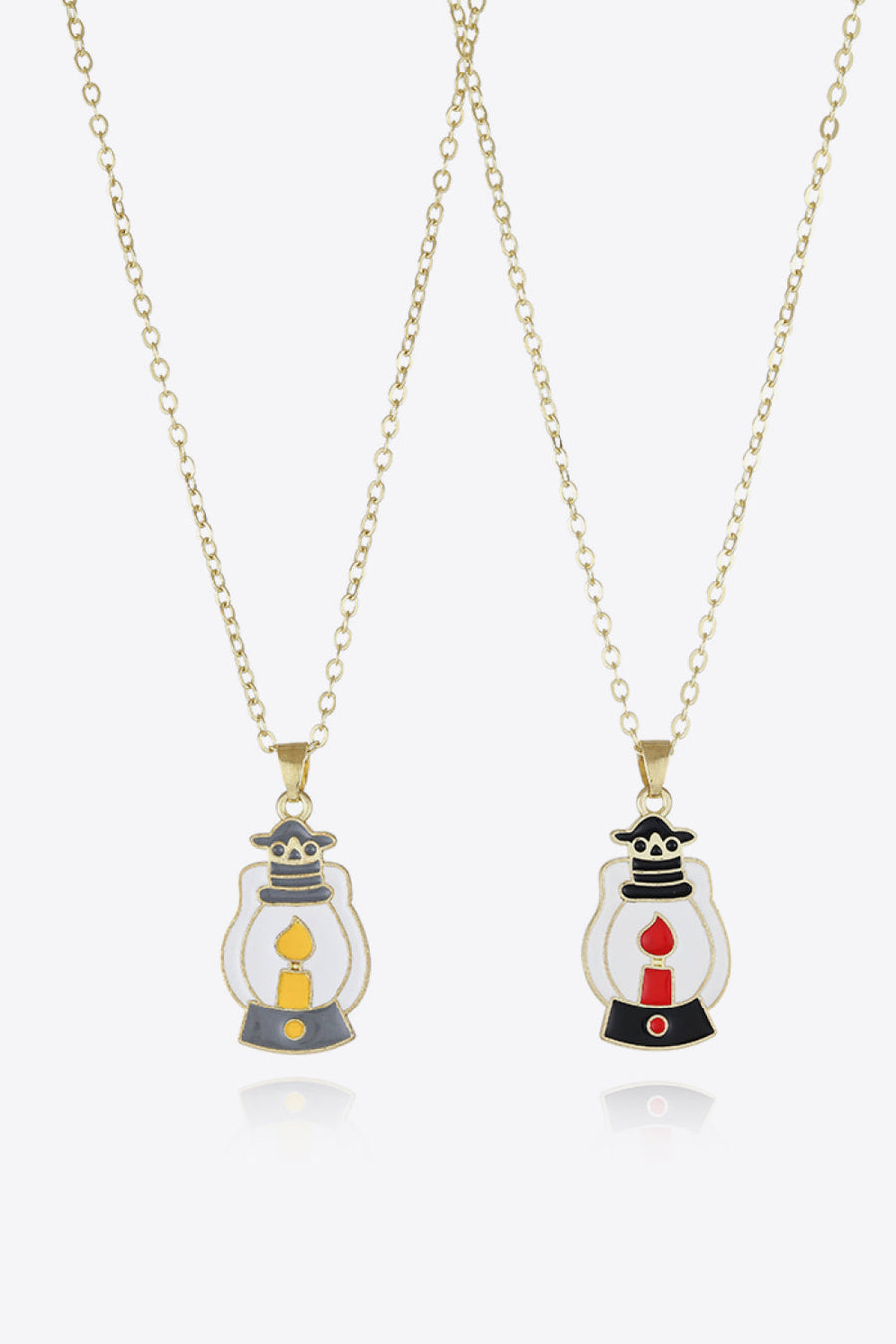 Spooky Season enamel pendant necklaces, one with yellow candle, one with red candle.