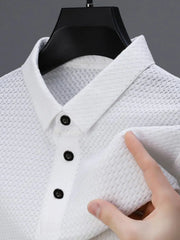 White textured pique polo shirt with refined collar and dark buttons.