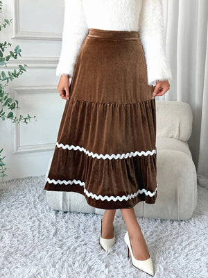Tiered velvet midi skirt in brown with white scalloped trim detail.