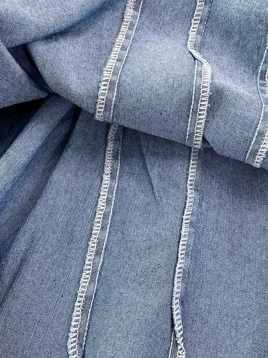 Blue denim A-line dress with corset detail and white contrast stitching.