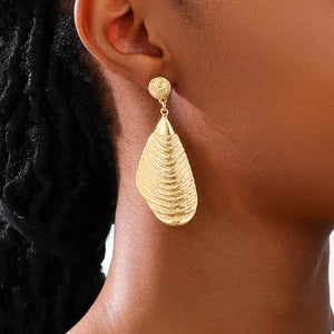 Textured gold dangle earrings with a teardrop-shaped, ridged pendant.