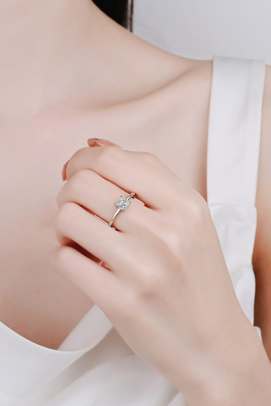 Prism cut moissanite silver ring with a square-shaped stone on a delicate band.