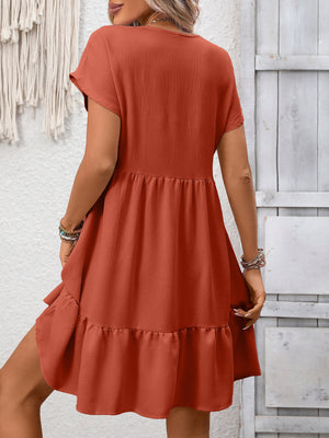Rust red V-neck mini dress with ruffle hem and short sleeves.