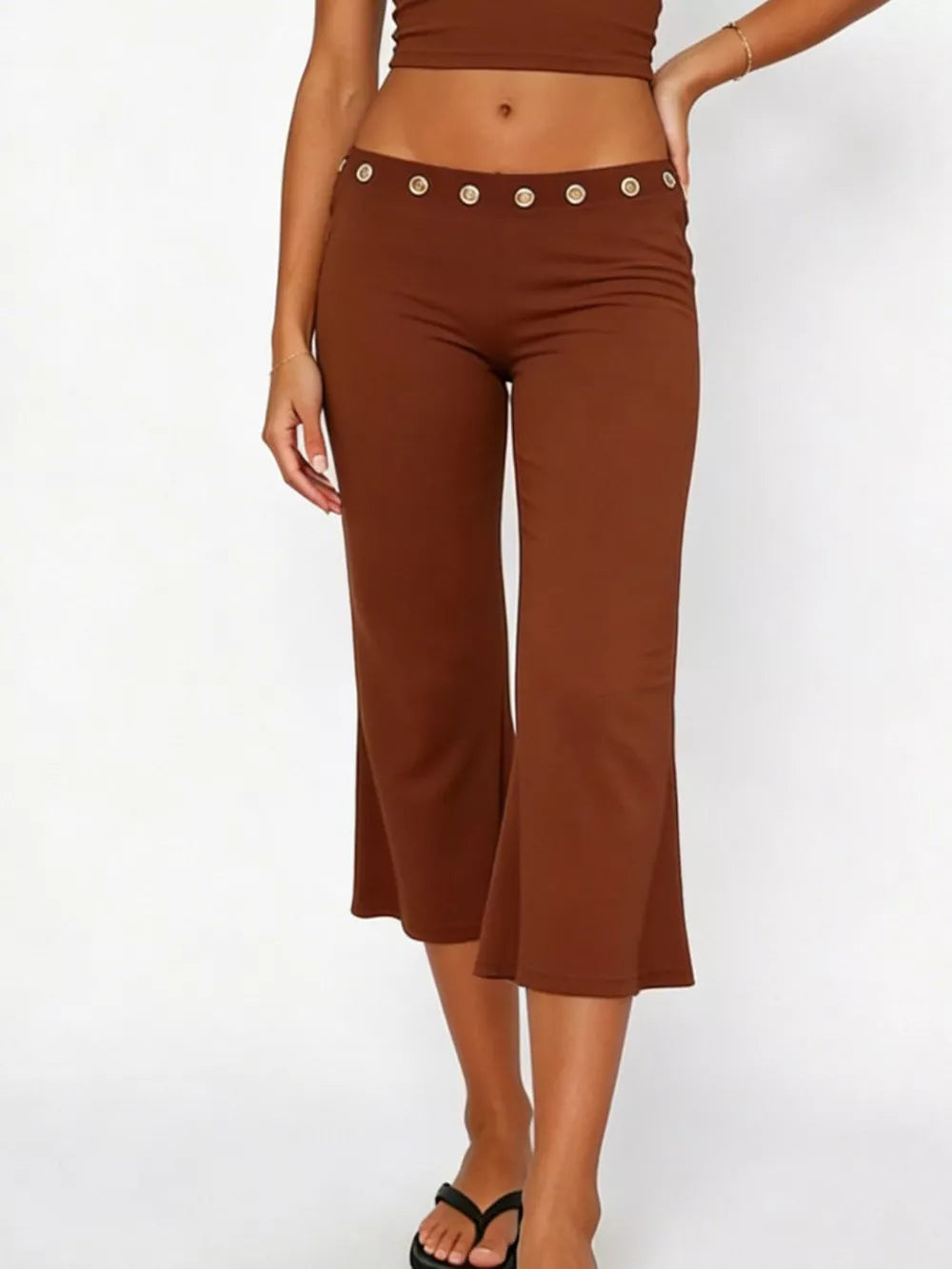 Dark brown maternity capri pants with flared hem and decorative button detail at the waist.