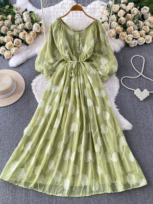 Green chiffon maxi dress with floral embroidery, puff sleeves, button-down front, and belted waist.