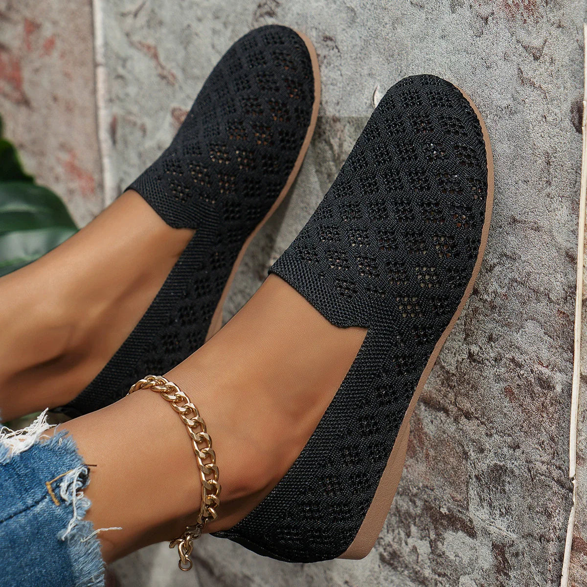 Black diamond knit loafers with a tan sole, featuring a gold chain anklet.