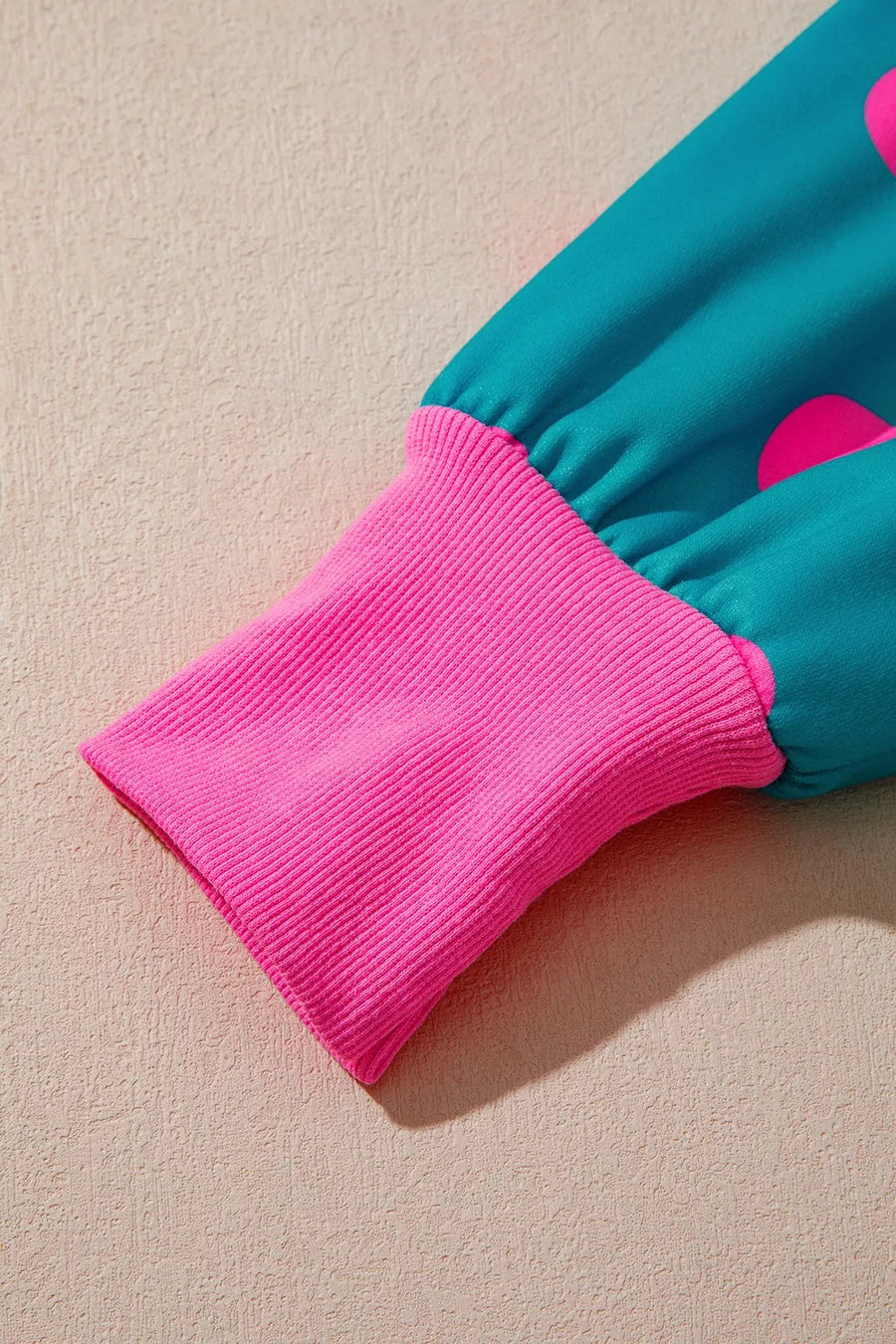 sweatshirt in teal with exposed seam and hip-length