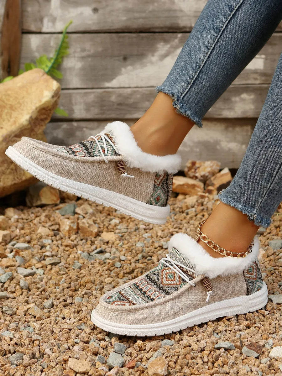 Southwestern print faux fur lined loafers in taupe with white laces and a gold ankle bracelet.