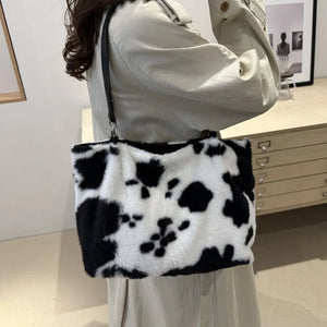 Cowhide print faux fur shopper bag with black trim and shoulder strap.