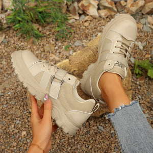 Beige lace up platform sneakers with chunky sole and buckle detail.