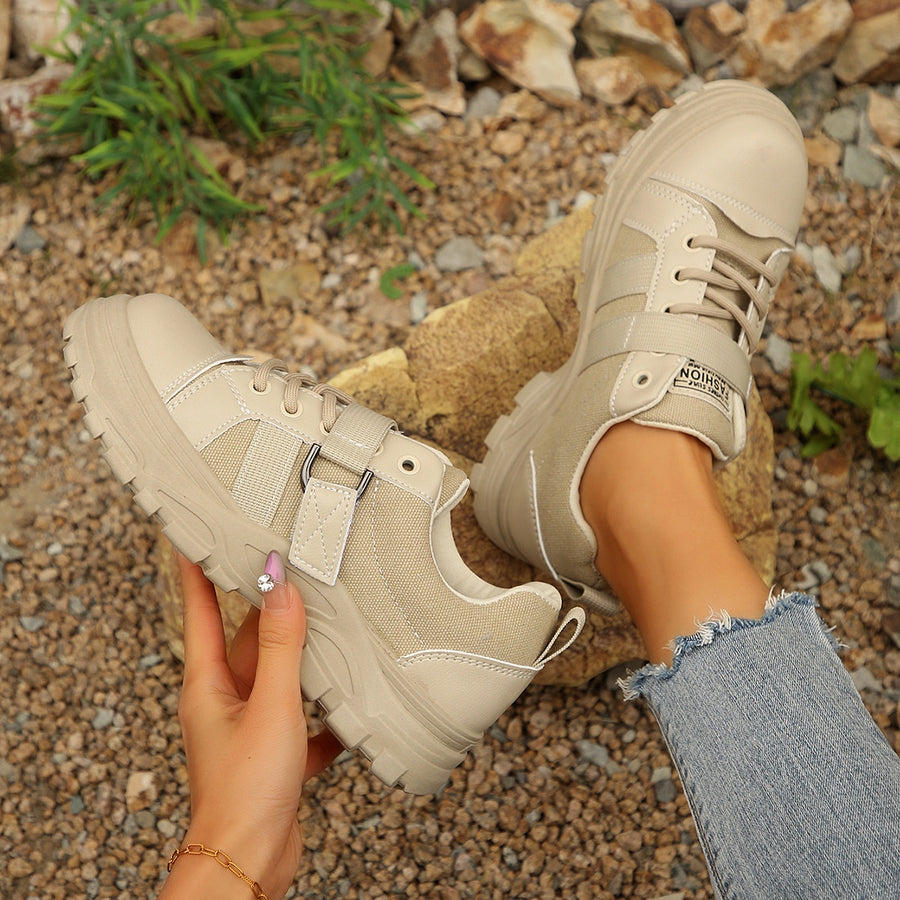 Beige lace up platform sneakers with chunky sole and buckle detail.